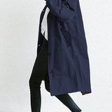 Lang trenchcoat for dame med hette og knappelukking